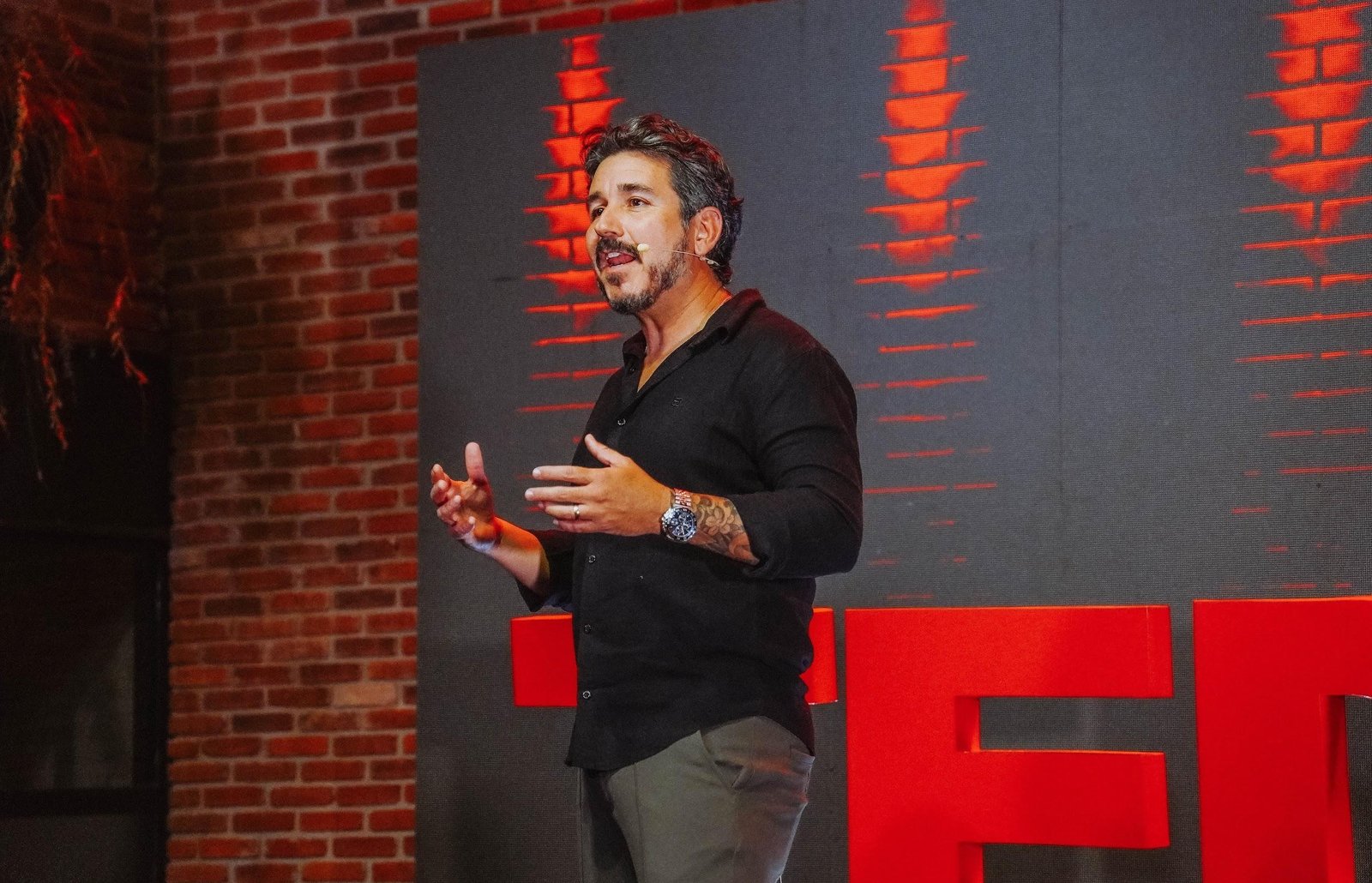 Dan Rocha palestrando em um palco TEDx